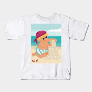 Cute little boy is on vacation building a sand castle on the beach Kids T-Shirt